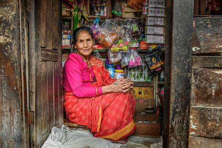 KATHMANDU, NEPAL - OCTOBER 19, 2015 : Old nepalese lady sells goods in her store.のeditorial素材