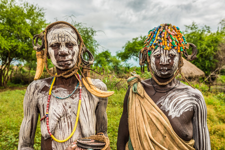 OMO VALLEY, ETHIOPIA - MAY 7, 2015 : Two women from the african tribe Mursi in their villageのeditorial素材