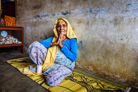 KATHMANDU, NEPAL - OCTOBER 23, 2015 : Very old woman welcomes visitors in a local retirement home