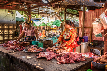YANGON, MYANMAR - JANUARY 19, 2016 : Asian woman butcher sells meat at a local market in Yangonのeditorial素材