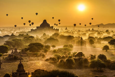 Scenic sunrise with many hot air balloons above Bagan in Myanmar. Bagan is an ancient city with thousands of historic buddhist temples and stupas.の写真素材