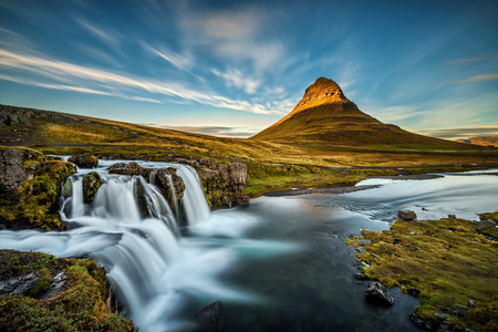 Summer sunset over the famous Kirkjufellsfoss Waterfall with Kirkjufell mountain in the background in Iceland. Long exposure.の写真素材