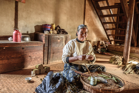 PINDAYA, MYANMAR - JANUARY 25, 2016 : Old woman working in her homeのeditorial素材