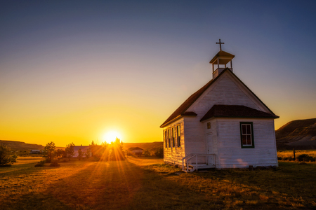 Summer sunset over the old wooden pioneer church in the ghost town of Dorothy in Alberta, Canada.の写真素材