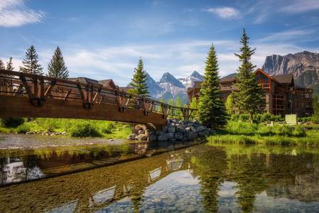 CANMORE, CANADA - JUNE 26, 2017 : Hotels in Canmore with mountain peaks in the background. Canmore is located in the Bow Valley near Banff National Park and is a popular tourist destination.のeditorial素材
