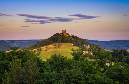 Upper church with two towers and baroque calvary in Banska Stiavnica, Slovaka at sunset. Banska Stiavnica is a completely preserved medieval town and a popular tourist destination.の写真素材