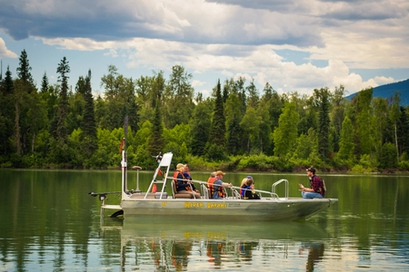 BLUE RIVER, CANADA - JUNE 30, 2017 : Tourists in life vests on a boat on a river safari tour.のeditorial素材