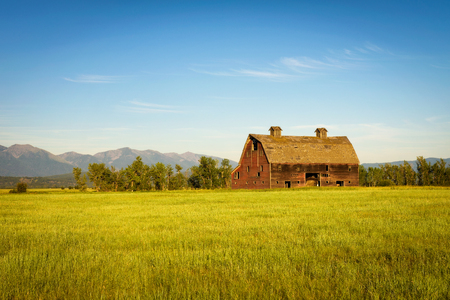 Summer sunset with an old barn in rural Montanaの写真素材