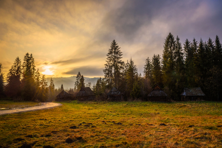Dirt road and old wooden houses under High Tatra Mountains in Polandの写真素材