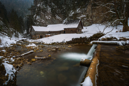 Old wooden water mill in winterの写真素材