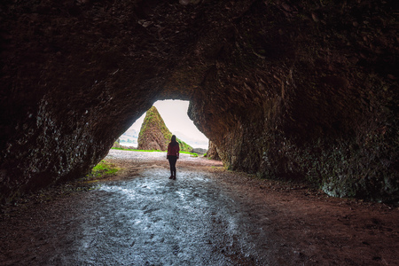 Woman inside Cushendun Cave in Northern Irelandの写真素材