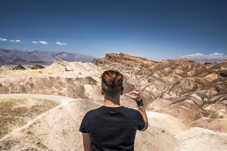 Death Valley and a visitor doing okay gesture with his handの写真素材