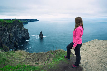 Young girl standing at the cliffs of Moherの写真素材