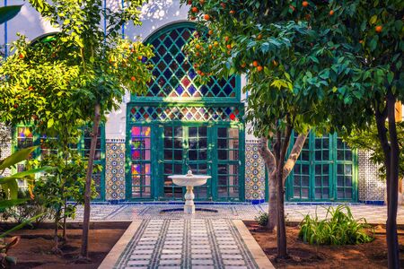 Small white fontaine among orange trees of Jardin Majorelle, Marrakech, Morocco