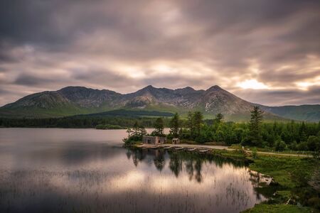 Lough Inagh in Ireland with a cabin and boats at the lake shoreの写真素材