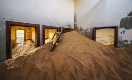 Ruins of a house filled with sand in the mining town Kolmanskop, Namibiaの写真素材