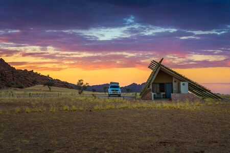 Sunrise above small chalets of a desert lodge near Sossusvlei in Namibia