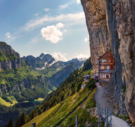 Swiss Alps and a restaurant under a cliff on mountain Ebenalp in Switzerlandの写真素材