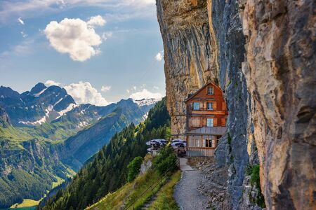 Swiss Alps and a restaurant under a cliff on mountain Ebenalp in Switzerlandの写真素材