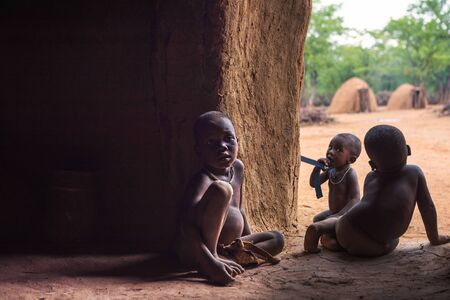 Three children of the Himba tribe in Namibia play in their hutのeditorial素材