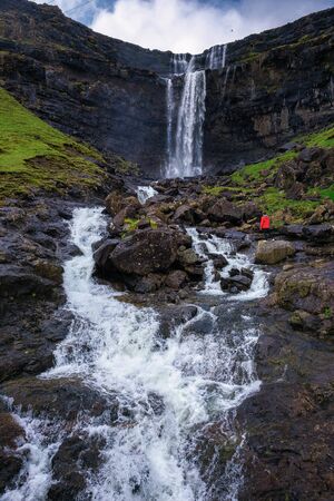 Tourist at the Fossa Waterfall on island Bordoy in the Faroe Islandsの写真素材