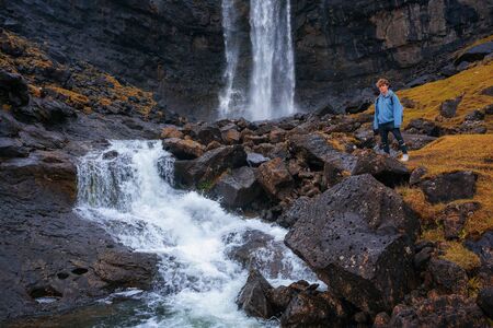 Tourist at the Fossa Waterfall on island Bordoy in the Faroe Islandsの写真素材