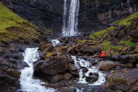 Tourist at the Fossa Waterfall on island Bordoy in the Faroe Islandsの写真素材