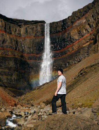 Tourist looking at the Oxarafoss waterfall in Icelandの写真素材