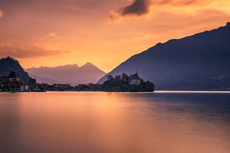 Sunset above Iseltwald peninsula and former castle in Switzerlandの写真素材