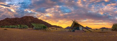 Sunrise above small chalets of a desert lodge near Sossusvlei in Namibiaの写真素材