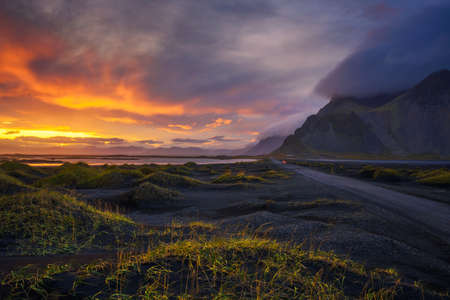 Gravel road at sunset with Vestrahorn mountain in the background, Icelandの写真素材
