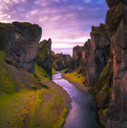 Deep Fjadrargljufur canyon and river flowing along the bottom of the canyon in Iceland at sunsetの写真素材