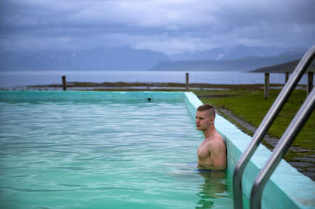 Boy bathes in Reykjafjardarlaug Hot Pool located in the Westfjords, Icelandの写真素材