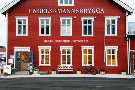 Red facade of a souvenir shop with a white bench in the Lofoten Islands, Norwayのeditorial素材