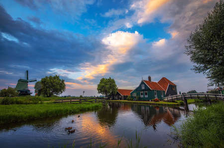 Historic farm houses in the holland village of Zaanse Schans at sunsetの写真素材