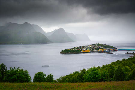 Husoy fishing village on the Senja Island in Norway with in heavy cloudsの写真素材