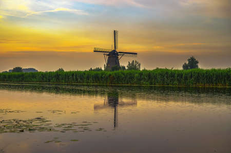 Old dutch windmill at sunset in Kinderdijk, Netherlandsの写真素材