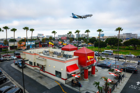 Alaska Airlines plane flies above In-N-Out Burger restaurant while landing at the Los Angeles International Airport LAXのeditorial素材