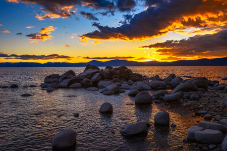 Sunset above rocky beach of Lake Tahoe in Californiaの写真素材