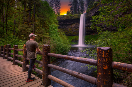 Tourist looking at the South Falls in Silver Falls State Park, Oregonの写真素材
