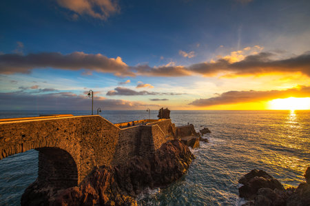 Sunset at the pier of Ponta do Sol in Madeira Island, Portugalの写真素材