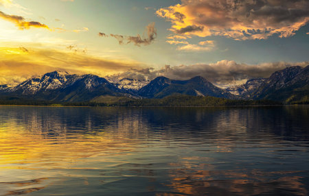 Summer sunset above Lake Tahoe with Sierra Nevada Mountains and reflectionの写真素材