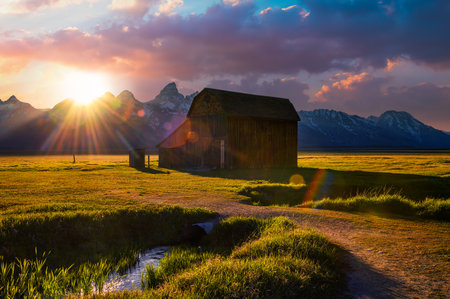 Sunset over a historic barn at Mormon Row in Grand Teton National Park, Wyomingの写真素材
