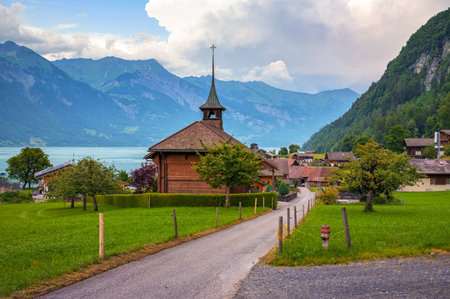 Swiss Reformed Church in Iseltwald, Switzerland, with Lake Brienz and mountain backdrop in view.の写真素材