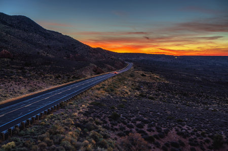 Remote road passes toward the Grand Canyon National Park, illuminated by a vivid Arizona sunset.の写真素材