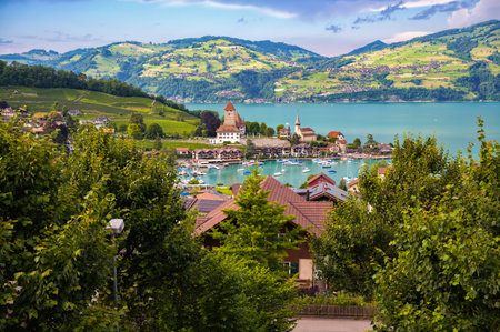 Picturesque view of Spiez Castle and the charming village of Spiez the Swiss canton of Bern, surrounded by greenery and overlooking Thun Lake, set against the lush Swiss hills.の写真素材