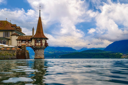 Close-up of Oberhofen Castle tower on Lake Thun with Swiss Alps in the background, Switzerlandの写真素材
