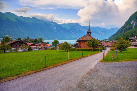 Swiss Reformed Church in Iseltwald, Switzerland, with Lake Brienz and mountain backdrop in view.の写真素材