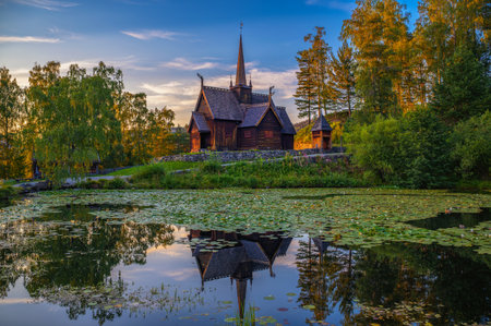 Historic Garmo Stave Church in Lillehammer, Norway, also known as Garmo stavkirke, reflected in a lily-covered pond at sunset.の写真素材