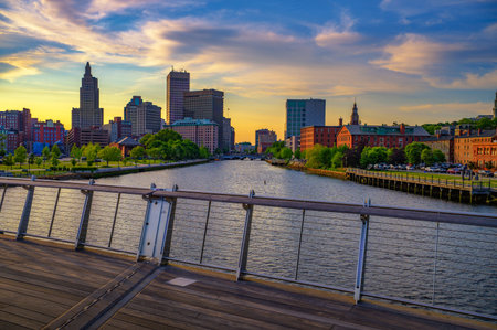 View of downtown Providence and the Providence River at colorful sunset, seen from a pedestrian footbridge in Rhode Island, USA.の写真素材